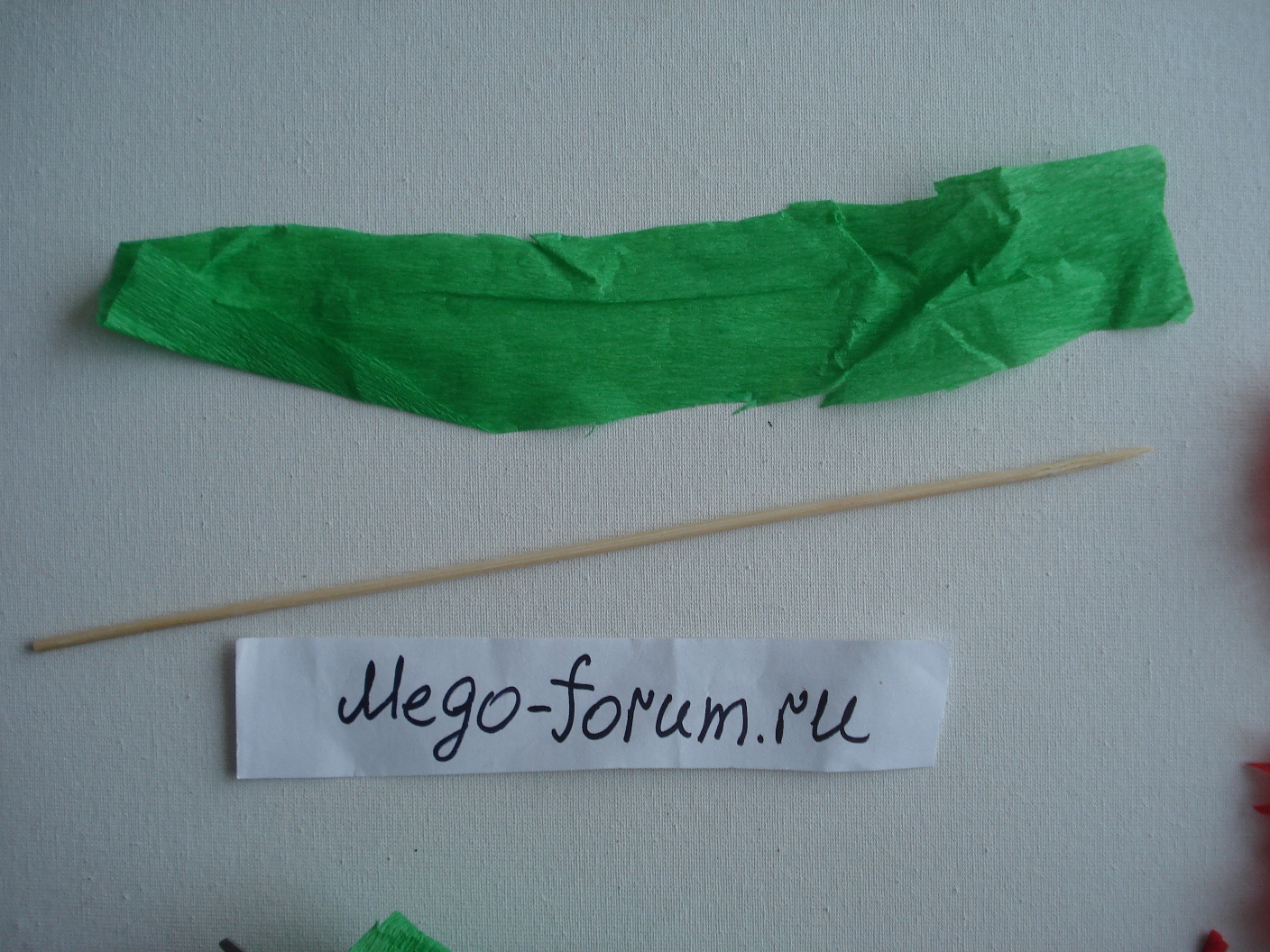  Сделаем стебель для гвоздики. Из гофрированной бумаги зеленого цвета вырежем длинную полоску.